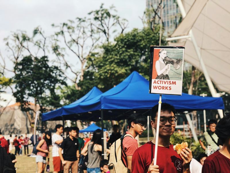 Demonstrator holding a sign reading Activism Works
