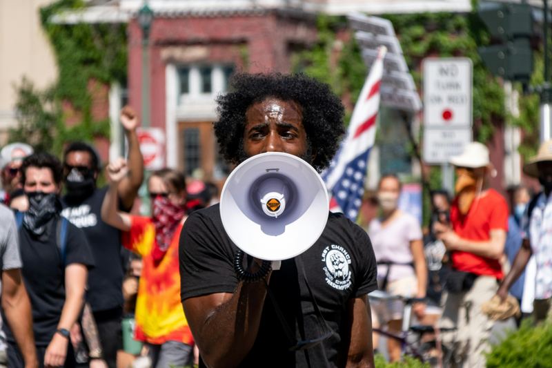 Campaigner speaking through a megaphone at a street demonstration